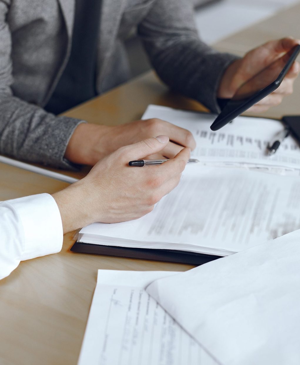 Business men sitting at the lawyers's desk. People signing important documents.